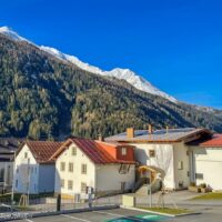 Pettneu am Arlberg in de lente, met de besneeuwde bergtoppen op de achtergrond