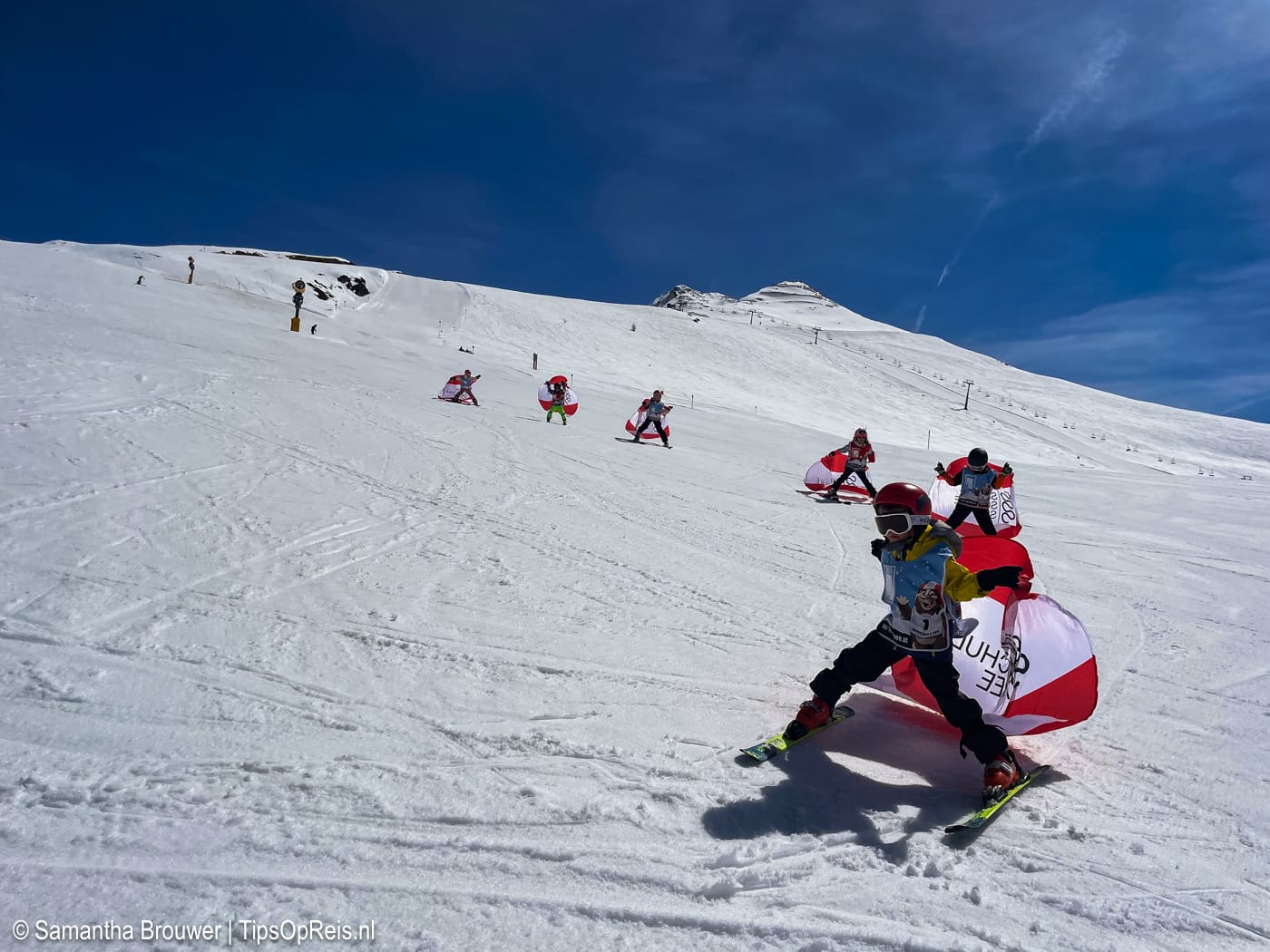 Kinderen in groepsles skiën van de piste met vlaggen tijdens skiles in See